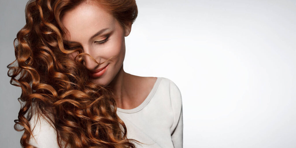 Woman with curly red hair and a white blouse